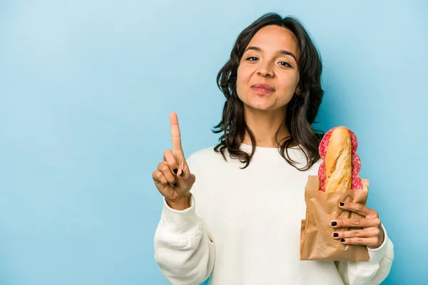 Young Hispanic Woman Eating Sandwich Isolates Blue Background Showing Number — Photo