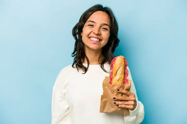 Young Hispanic Woman Eating Sandwich Isolates Blue Background Happy Smiling — Stockfoto