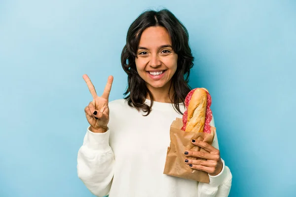 Young Hispanic Woman Eating Sandwich Isolates Blue Background Showing Number — Stockfoto