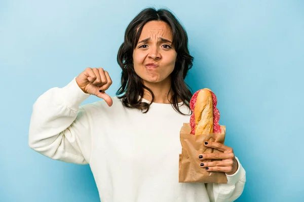 Young Hispanic Woman Eating Sandwich Isolates Blue Background Showing Dislike — Stockfoto