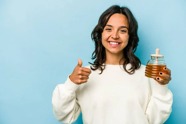 Young Hispanic Woman Holding Honey Isolated Blue Background Smiling Raising — Zdjęcie stockowe