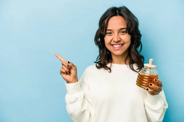 Junge Hispanische Frau Hält Einen Honig Isoliert Auf Blauem Hintergrund — Stockfoto