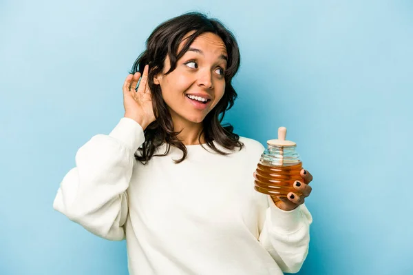 Young Hispanic Woman Holding Honey Isolated Blue Background Trying Listening — Zdjęcie stockowe