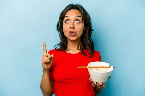 Young Hispanic Woman Eating Noodles Isolated Blue Background Pointing Upside — Stockfoto