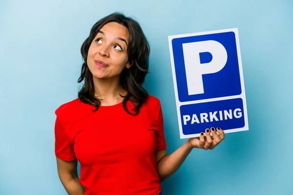 Ung Latinamerikansk Kvinna Håller Parkerings Skylt Isolerad Blå Bakgrund Drömmer — Stockfoto