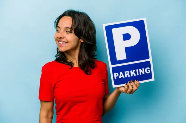 Ung Latinamerikansk Kvinna Håller Parkerings Skylt Isolerad Blå Bakgrund Ser — Stockfoto