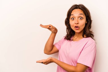 Beyaz arka planda izole edilmiş genç İspanyol kadın elleri arasında bir kopya alanı tutarken şok ve hayrete düştü..