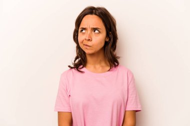 Beyaz arka planda izole edilmiş genç İspanyol kadın kafası karışmış, şüpheli ve güvensiz hissediyor..