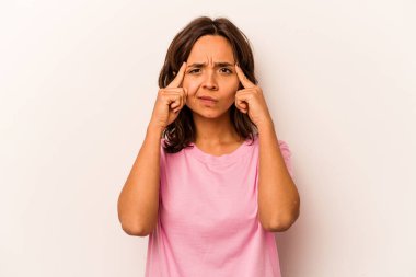 Beyaz arka planda izole edilmiş genç İspanyol kadın bir göreve odaklanmış, işaret parmaklarını işaret ediyor..