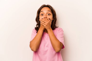 Beyaz arka planda izole edilmiş genç İspanyol kadın elleriyle ağzını kapatırken şok oldu..