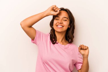 Beyaz arka planda izole edilmiş genç İspanyol kadın özel bir günü kutluyor, atlıyor ve enerjiyle kollarını kaldırıyor..