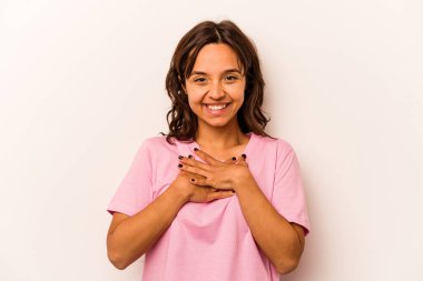 Beyaz arka planda izole edilmiş genç İspanyol kadın yüksek sesle gülüyor elini göğsüne koyuyor..