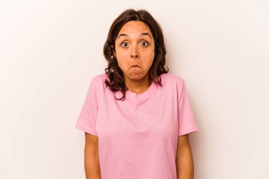 Beyaz arka planda izole edilmiş genç İspanyol kadın omuz silkiyor ve gözleri açık..