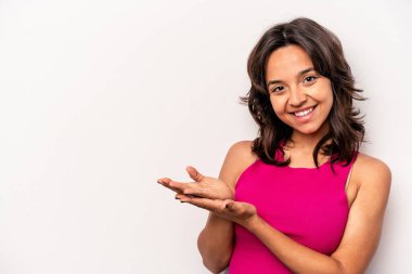 Beyaz arka planda izole edilmiş genç İspanyol kadın avucunun içinde bir kopya alanı tutuyor..