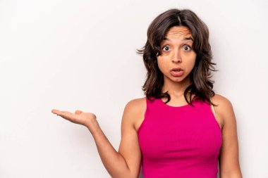 Beyaz arka planda izole edilmiş genç İspanyol kadın, avuç içi fotokopi alanı tutmaktan etkilenmiş..