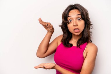 Beyaz arka planda izole edilmiş genç İspanyol kadın elleri arasında bir kopya alanı tutarken şok ve hayrete düştü..