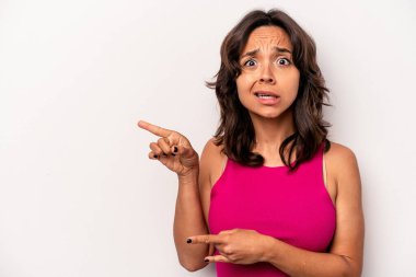 Beyaz arka planda izole edilmiş genç İspanyol kadın işaret parmağıyla fotokopi alanını işaret ederek şok oldu..