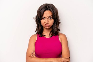 Beyaz arka planda izole edilmiş, hoşnutsuzca kaşlarını çatan, kollarını kavuşturan genç bir İspanyol kadın..