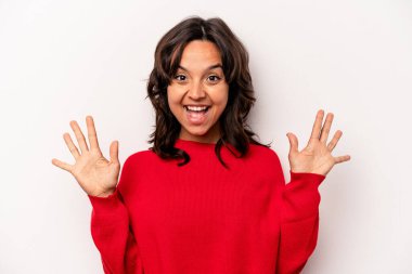 Beyaz arka planda izole edilmiş genç İspanyol kadın on numarayı elleriyle gösteriyor..