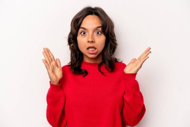 Young hispanic woman isolated on white background celebrating a victory or success, he is surprised and shocked.