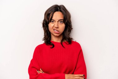 Beyaz arka planda izole edilmiş genç İspanyol kadın alaycı bir ifadeyle kameraya bakıyor..