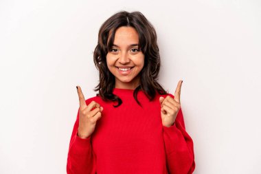 Beyaz arka planda izole edilmiş genç İspanyol kadın iki parmağı da boş bir alan gösteriyor..