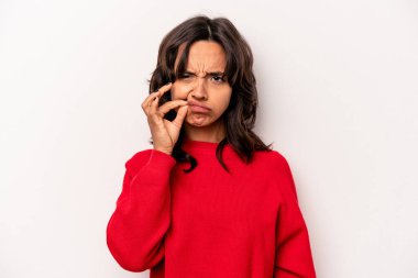 Beyaz arka planda izole edilmiş genç İspanyol kadın parmakları dudaklarında bir sır saklıyor..