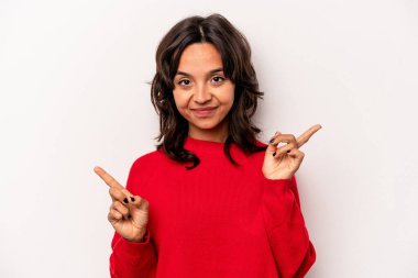 Beyaz arka planda izole edilmiş genç İspanyol kadın farklı kopya alanlarını gösteriyor, birini seçiyor, parmaklarıyla gösteriyor..