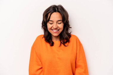 Beyaz arka planda izole edilmiş genç İspanyol kadın gülüyor ve gözlerini kapıyor, rahatlamış ve mutlu hissediyor..