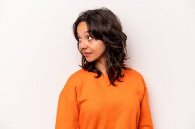 Beyaz arka planda soyutlanmış genç İspanyol kadın gülümseyen, neşeli ve keyifli bir kenara bakıyor..