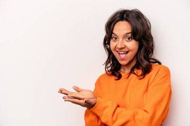 Beyaz arka planda izole edilmiş genç İspanyol kadın avucunun içinde bir kopya alanı tutuyor..