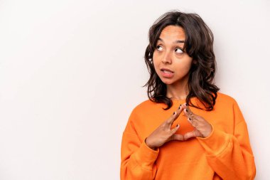 Latin kökenli genç bir kadın beyaz arka planda izole edilmiş bir plan kuruyor, bir fikir kuruyor..