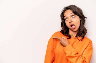 Latin kökenli genç bir kadın beyaz arka planda izole edilmiş, başparmak uzakta, gülen ve kaygısız..