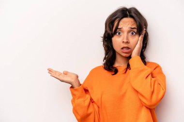 Beyaz arka planda izole edilmiş genç İspanyol kadın, avuç içi fotokopi alanı tutmaktan etkilenmiş..