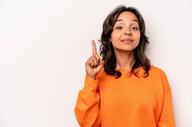 Beyaz arka planda izole edilmiş genç İspanyol kadın bir numarayı parmağıyla gösteriyor..