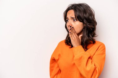 Beyaz arka planda izole edilmiş genç İspanyol kadın gördüğü bir şey yüzünden şoka uğruyor..