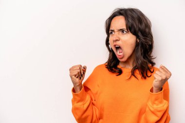 Beyaz arka planda izole edilmiş genç İspanyol kadın zaferden sonra yumruk kaldırıyor, kazanan konsept..