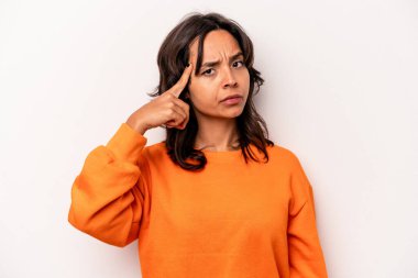 Beyaz arka planda izole edilmiş genç İspanyol bir kadın şakağı parmağıyla işaret ediyor, düşünüyor ve bir göreve odaklanıyor..