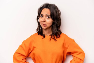 Beyaz arka planda izole edilmiş genç İspanyol kadın kafası karışmış, şüpheli ve güvensiz hissediyor..