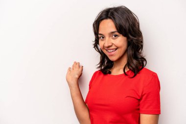 Beyaz arka planda izole edilmiş genç İspanyol kadın hoş bir yüz ifadesi sergiliyor..