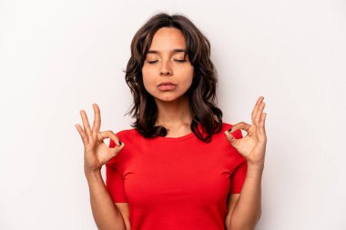 Beyaz arka planda izole edilmiş genç İspanyol kadın sıkı çalışma gününden sonra rahatlıyor, yoga yapıyor..