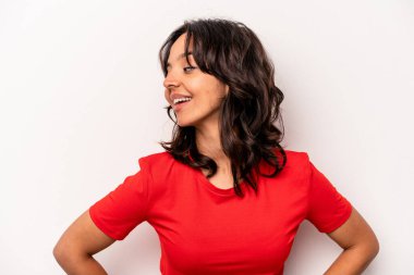 Beyaz arka planda izole edilmiş genç İspanyol kadın ellerini kalçasından ayırmıyor..