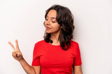 Beyaz arka planda izole edilmiş genç İspanyol kadın neşeli ve kaygısız parmakları olan bir barış sembolü gösteriyor..