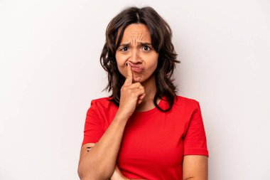 Beyaz arka planda izole edilmiş genç İspanyol kadın alaycı bir ifadeyle kameraya bakıyor..