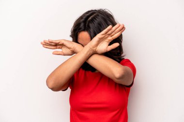 Beyaz arka planda izole edilmiş genç İspanyol kadın iki kolu çapraz tutuyor, inkar kavramı.