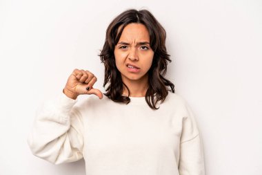 Beyaz arka planda izole edilmiş genç İspanyol kadın baş parmağını aşağı gösteriyor, hayal kırıklığı konsepti.