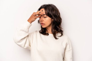 Beyaz arka planda izole edilmiş genç İspanyol kadın başı ağrıyor, yüzüne dokunuyor..