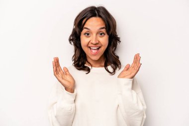 Beyaz arka planda izole edilmiş genç İspanyol kadın yüksek sesle gülüyor elini göğsüne koyuyor..