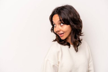 Beyaz arka planda soyutlanmış genç İspanyol kadın gülümseyen, neşeli ve keyifli bir kenara bakıyor..