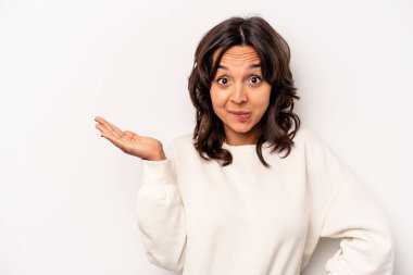 Beyaz arka planda izole edilmiş genç İspanyol kadın bir avuç içinde fotokopi alanı ve belinde bir el daha gösteriyor..